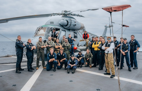Sailors and aviators in front of a Seasprite helicopter on the day of the launch.