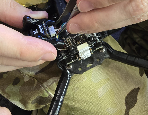 A member of the NZDF Drone Racing Team makes some quick adjustments to their drone during the competition
