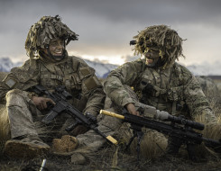 Two soldiers smiling at each other while sitting down in the Waiouru Military Training Area