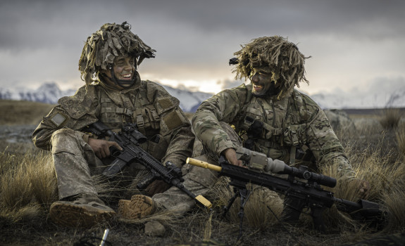 Two soldiers smiling at each other while sitting down in the Waiouru Military Training Area